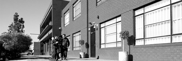 Black and white image of workers outside a building