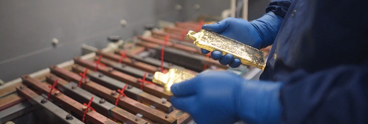 Team member holding two large gold bars for sorting